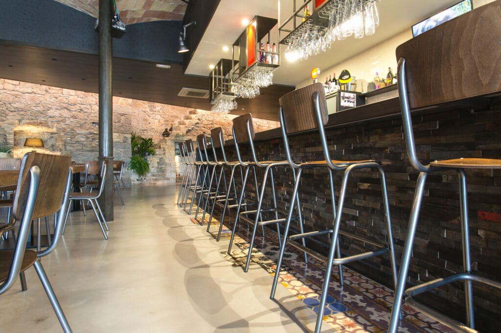 Restaurante estilo industrial con taburetes, sillas y mesas