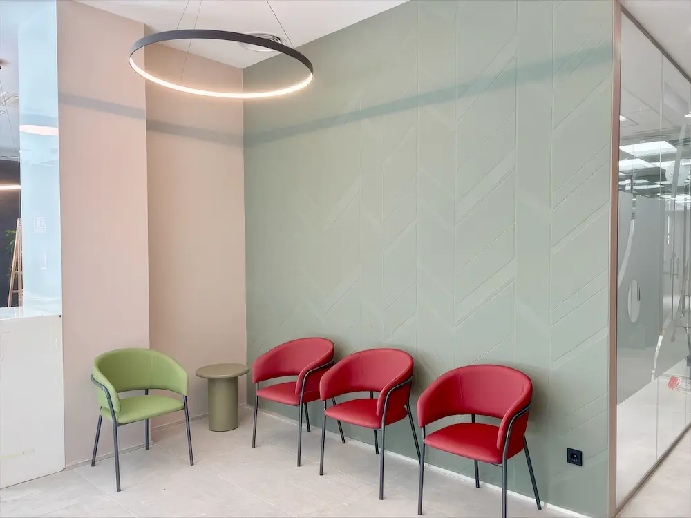 sillones tapizados verdes y rojos en sala de espera clinica dental mobiliario Ingenia Contract